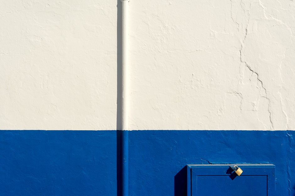 A white and blue painted wall with a door.