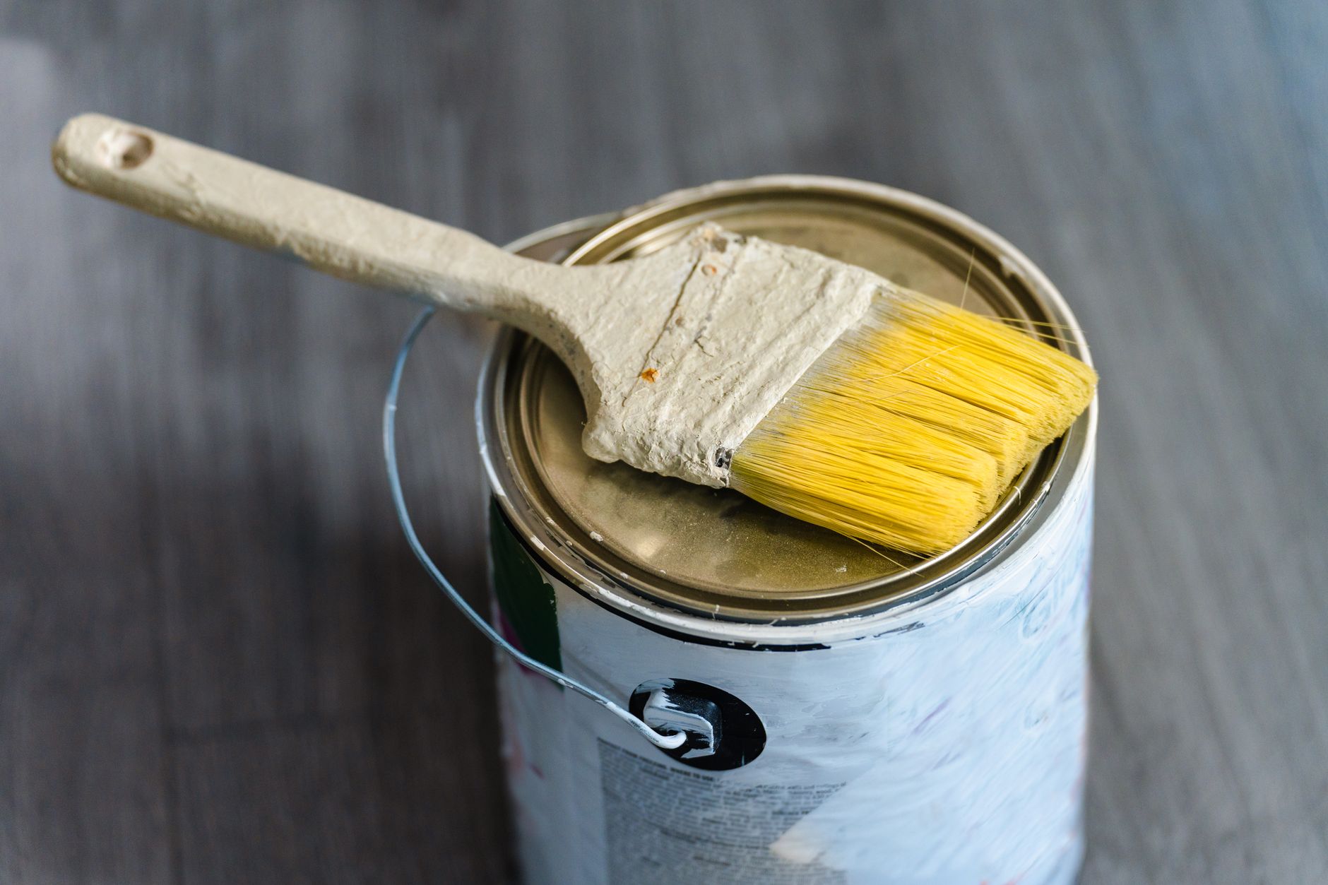 A close-up image of a paintbrush resting on a paint can, ideal for DIY projects