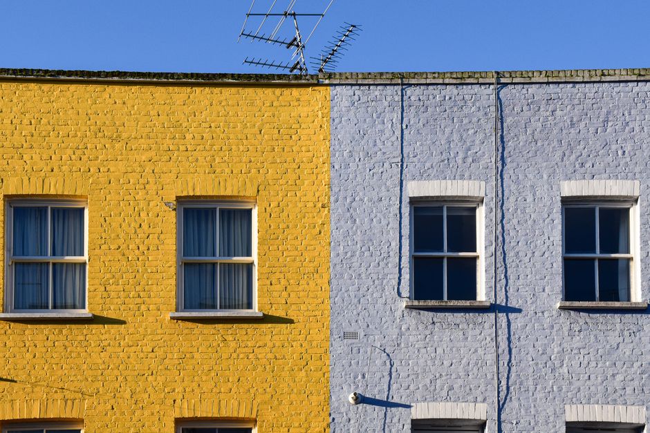 Yellow and blue painted townhouse fronts in a row.